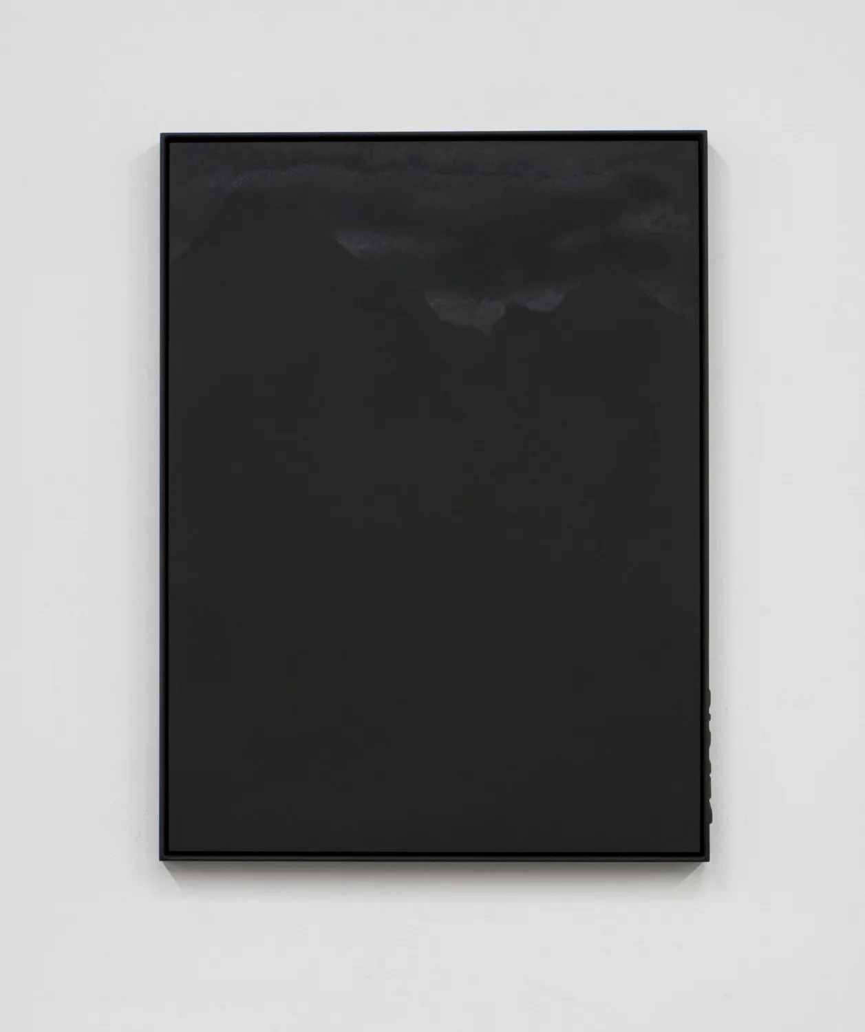 A small panel black steel plate piece that represents a mountain range and sky