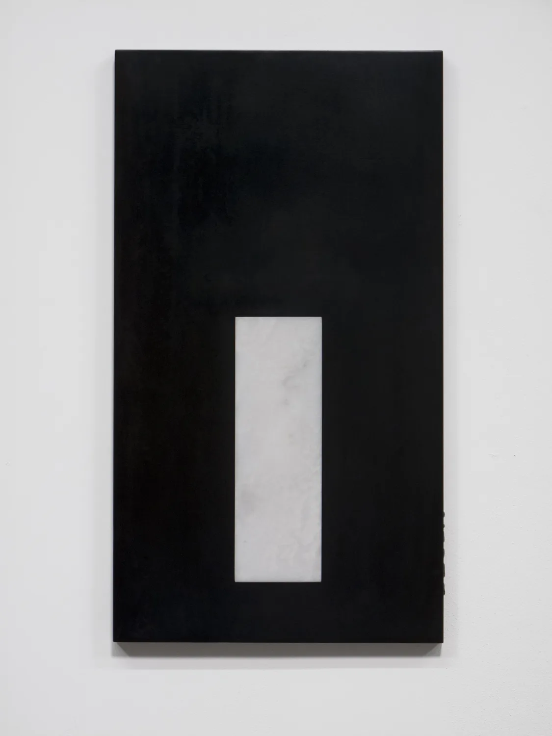 A small panel black chrome plated steel piece that has carrara marble on the middle