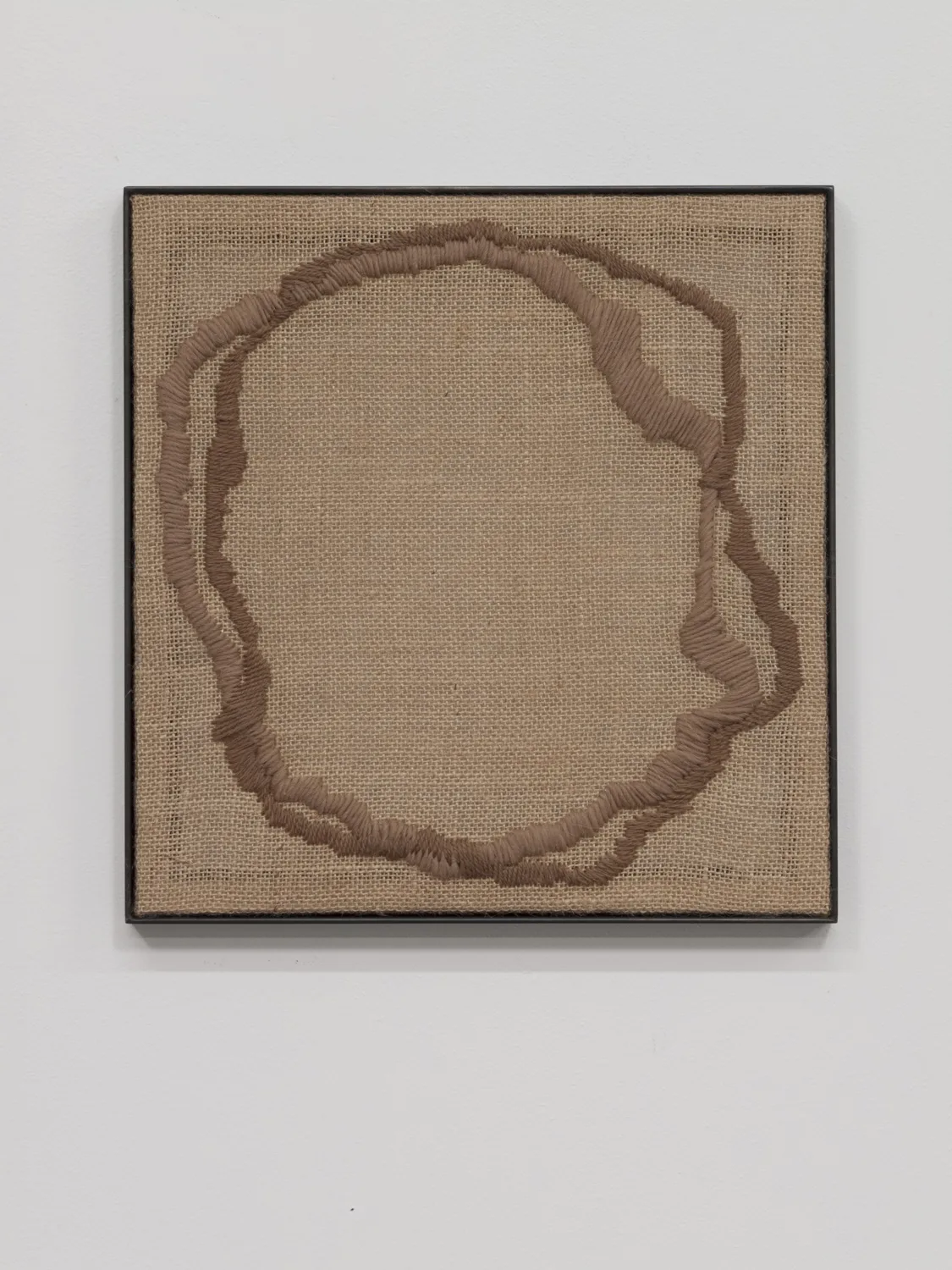 A textile artwork that shows a vessel, an egg, a portal or a celestial shape that embroidered on a burlap