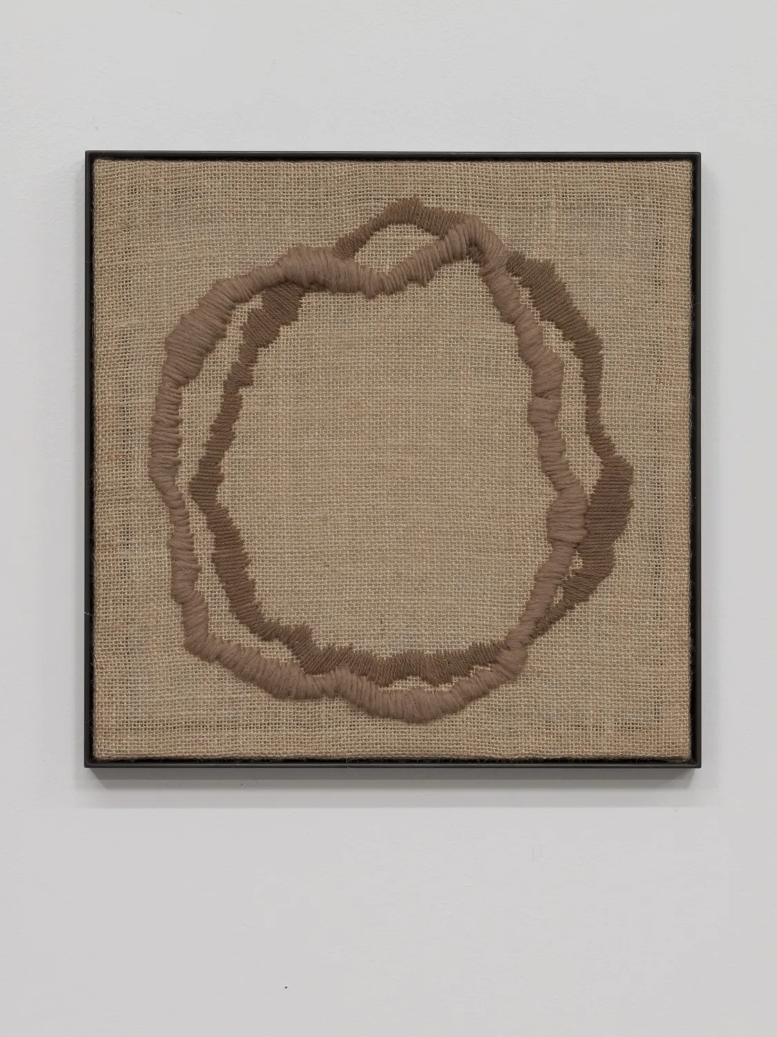 A textile artwork that shows a vessel, an egg, a portal or a celestial shape that embroidered on a burlap