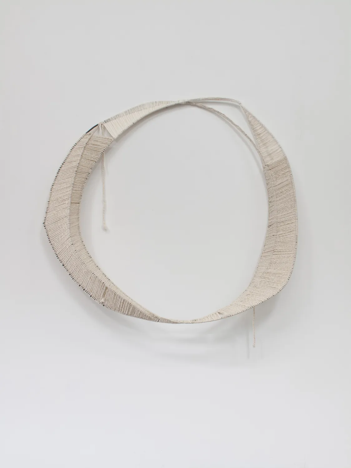 A textile artwork that shows a vessel, an egg, a portal or a celestial shape that embroidered on a burlap