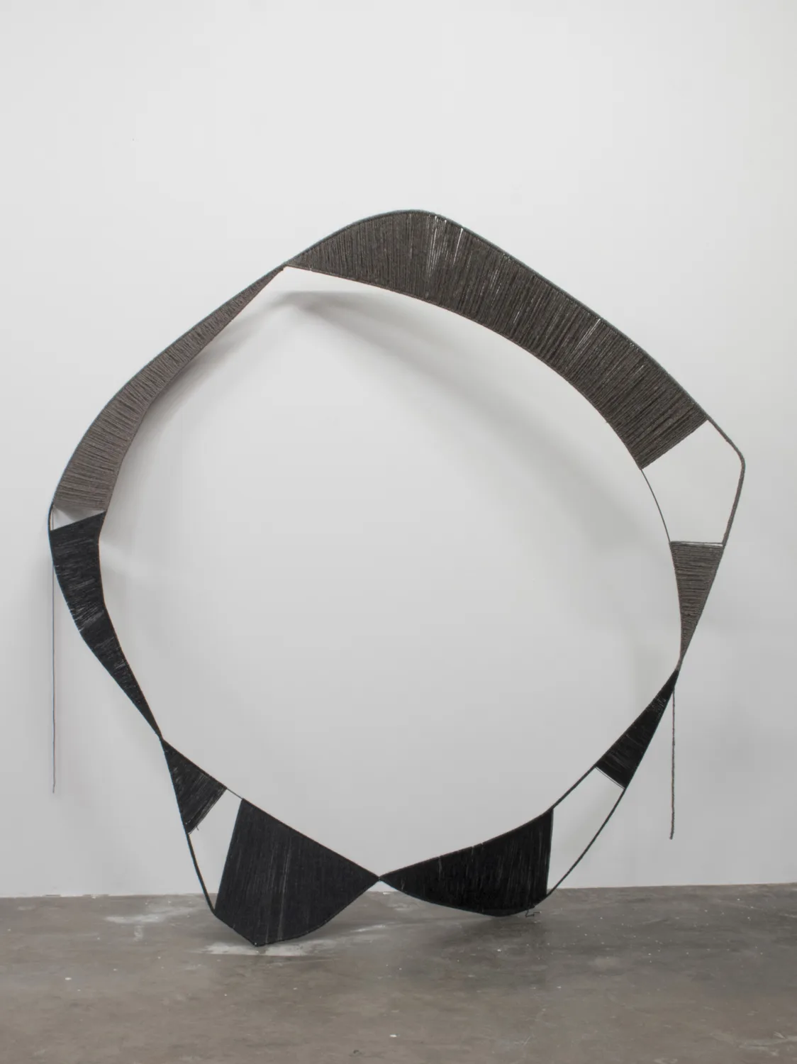 A sculpture that irregular steel hoops that black structures with spun white wool, contrasting soft and hard, warm and cool, and heavy and light
