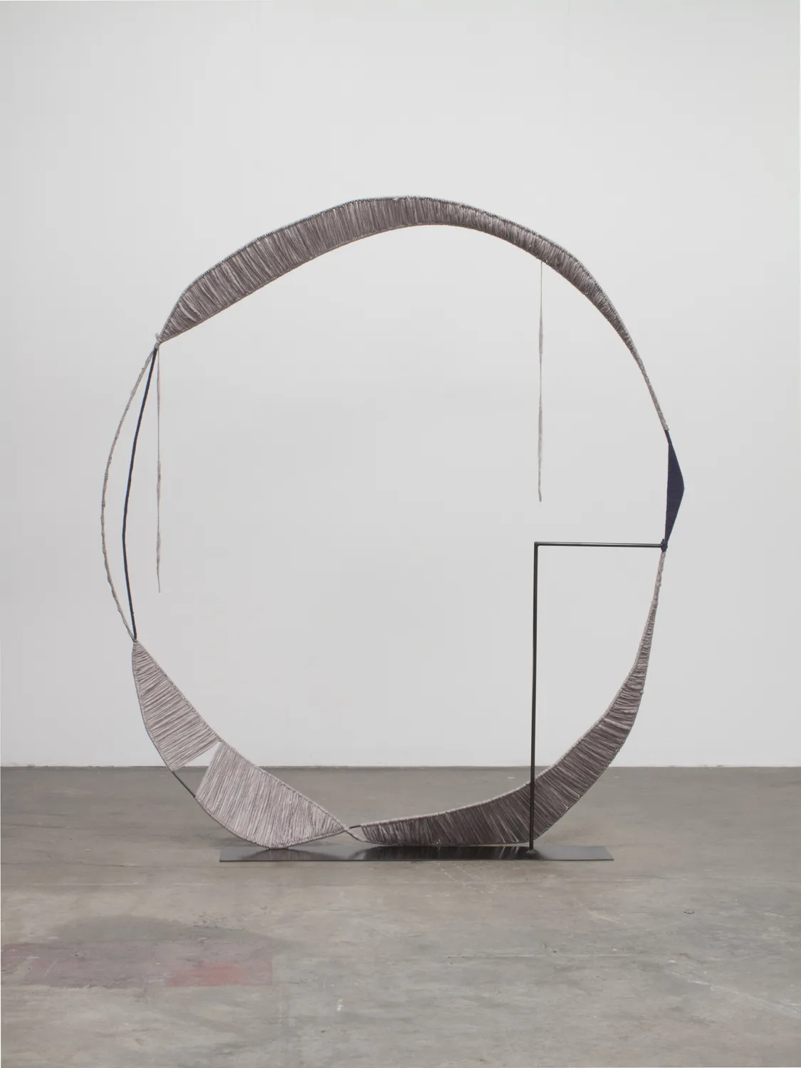 A sculpture that irregular steel hoops that steel structures with spun gray wool, contrasting soft and hard, warm and cool, and heavy and light