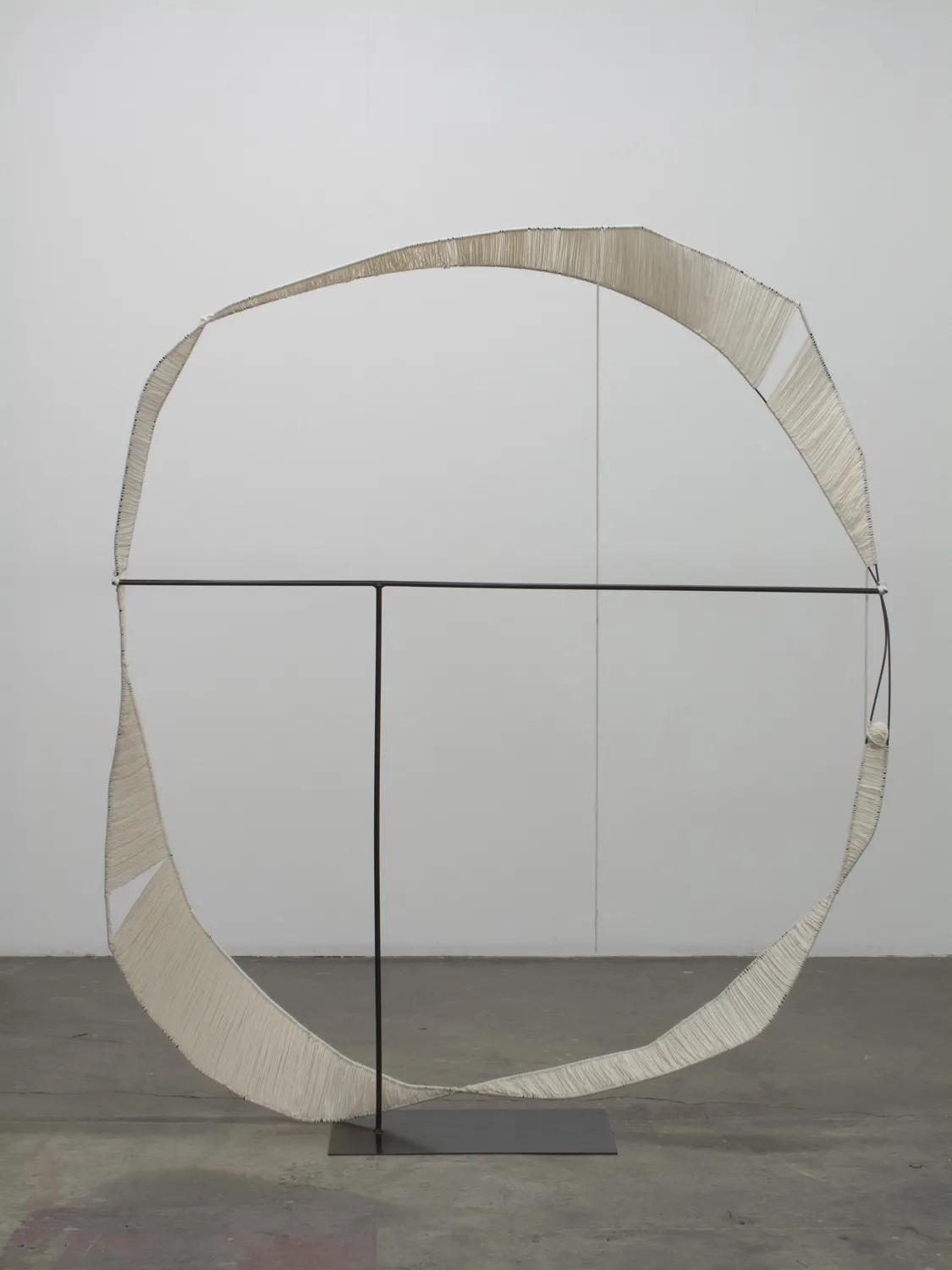 A sculpture that irregular steel hoops that steel structures with spun white wool, contrasting soft and hard, warm and cool, and heavy and light