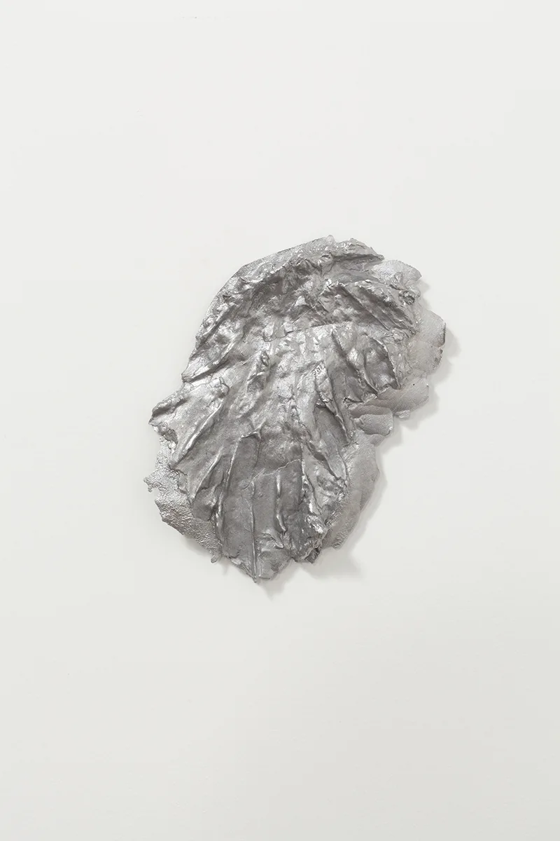 Shit 2 by Tanya Brodsky, Cast aluminum, 7 1/2 x 9 x ½ inches