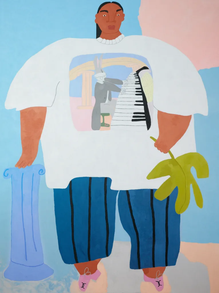 A lady is standing and resting her left hand on a small pillar while the other one is holding a fern leave