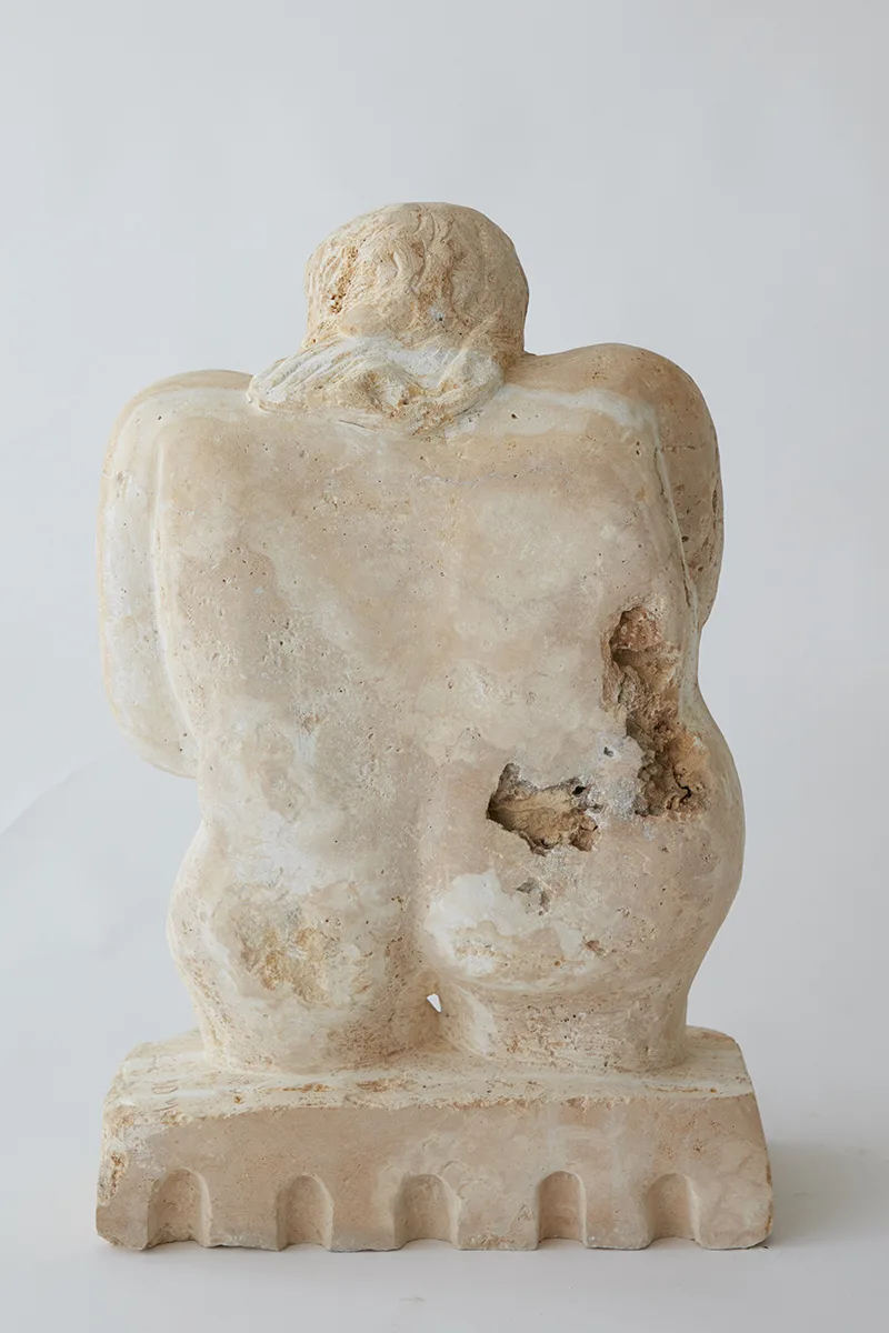 A detail image of a white sculpture of a human figure