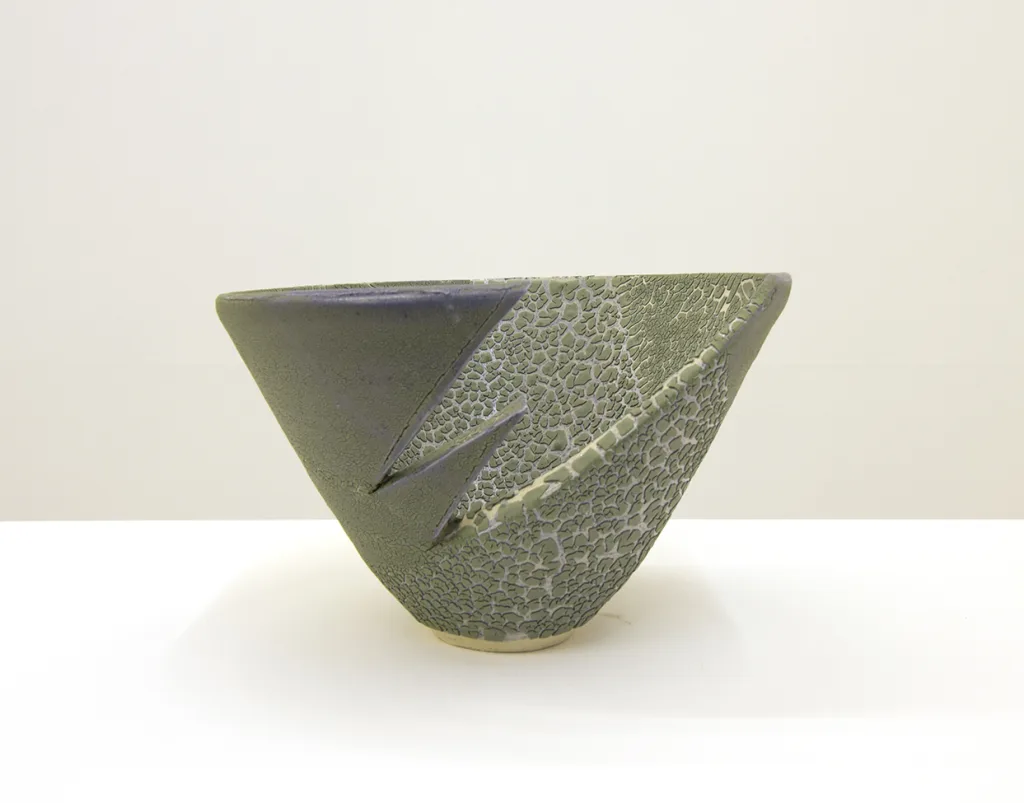A ceramic that shows a cracked surfaces resembling reptilian scales or lichen.