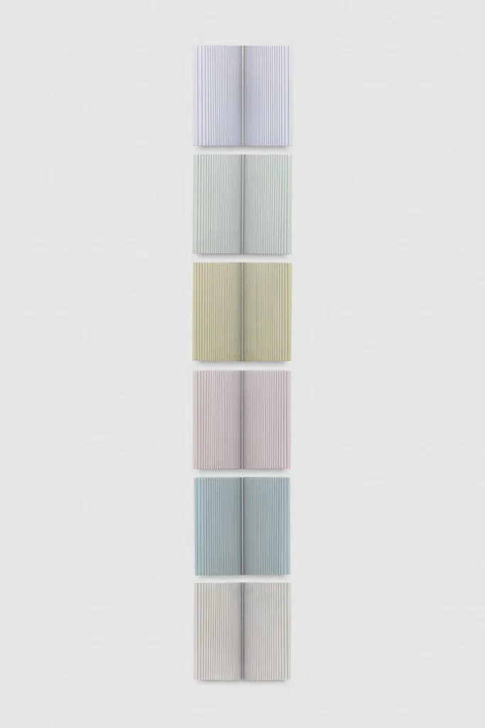 A wall installation that consists of six panels that are painted of pastel colors