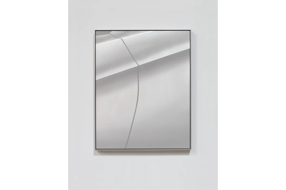 A small panel sandblasted aluminum piece that represents a car fender