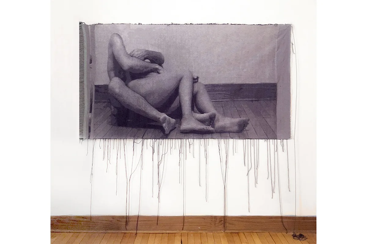 A woven tapestry depicts photographic image of two nude bodies that is intimate