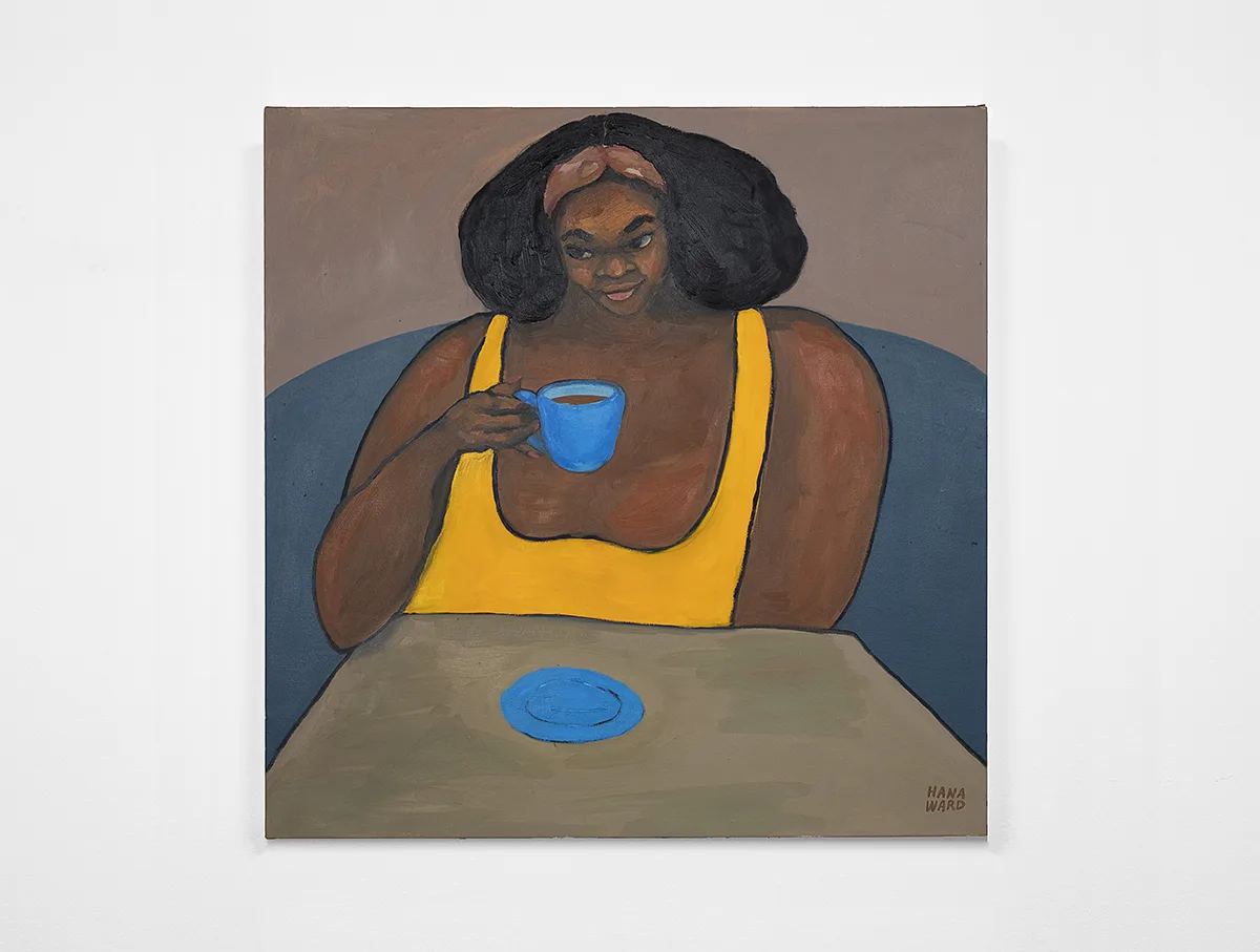 A medium-dark-skinned female holds a cup of coffee and leaning her right elbow on the table