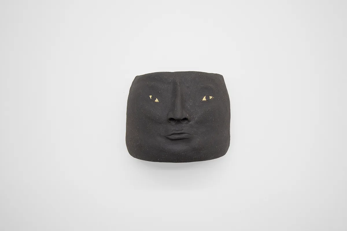 A grayish-black ceramic human head
