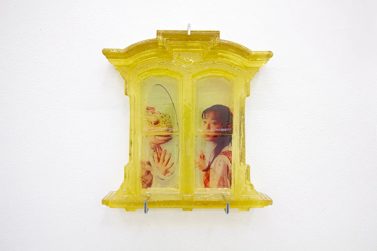 A yellow window and a picture of an iguana and a lady were attached to the glass of the window