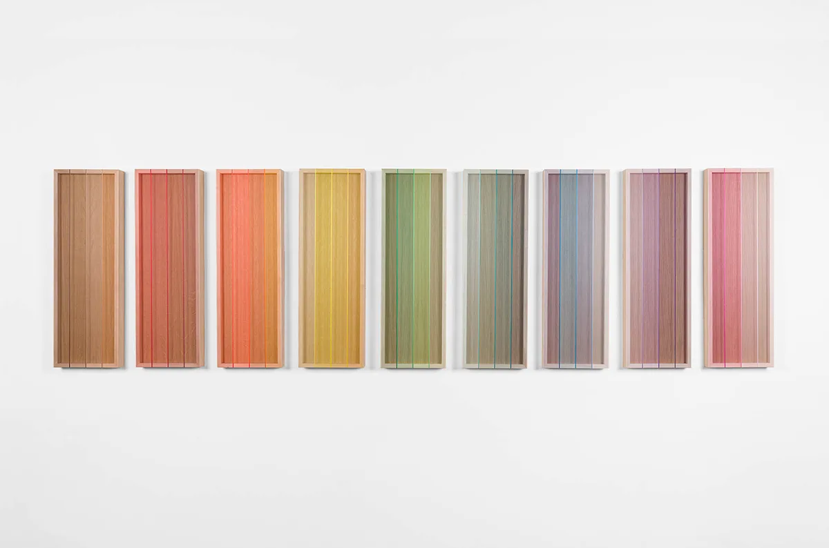 A wall installation that consists of nine panels that are painted of bright and vivid colors