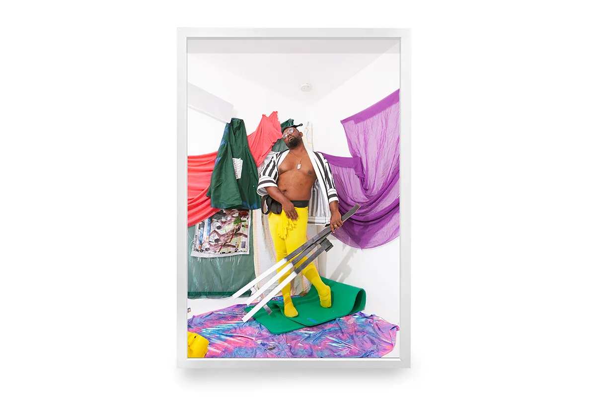 A dark skinned man wearing a kimono and a yellow yoga pants