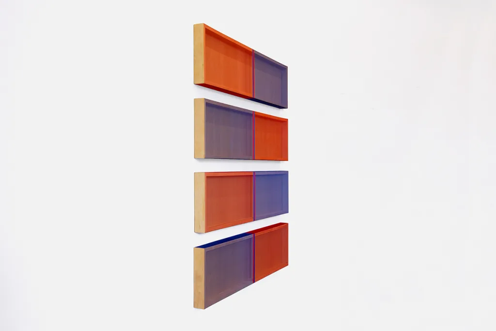 A side view image of a wall installation that consists of four panels that are painted of earth tone colors