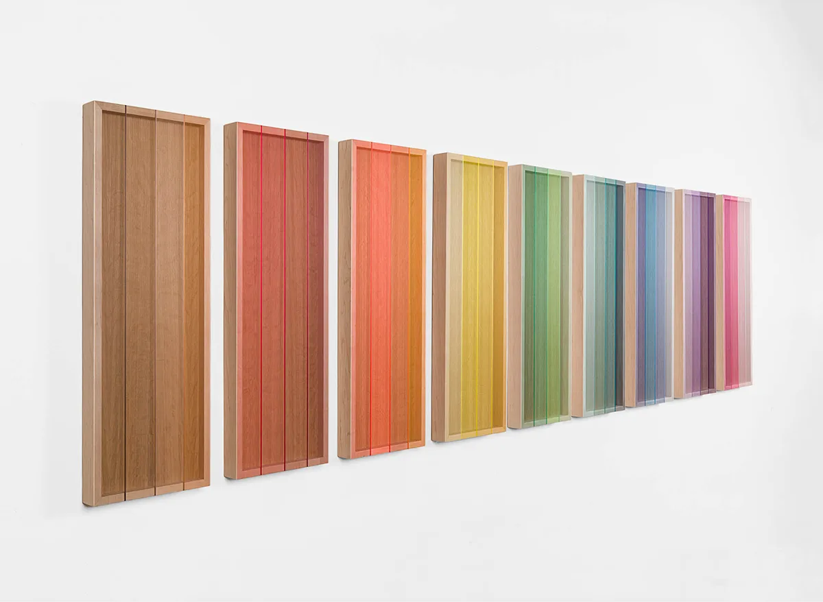 A side view image of a wall installation that consists of nine panels that are painted of bright and vivid colors