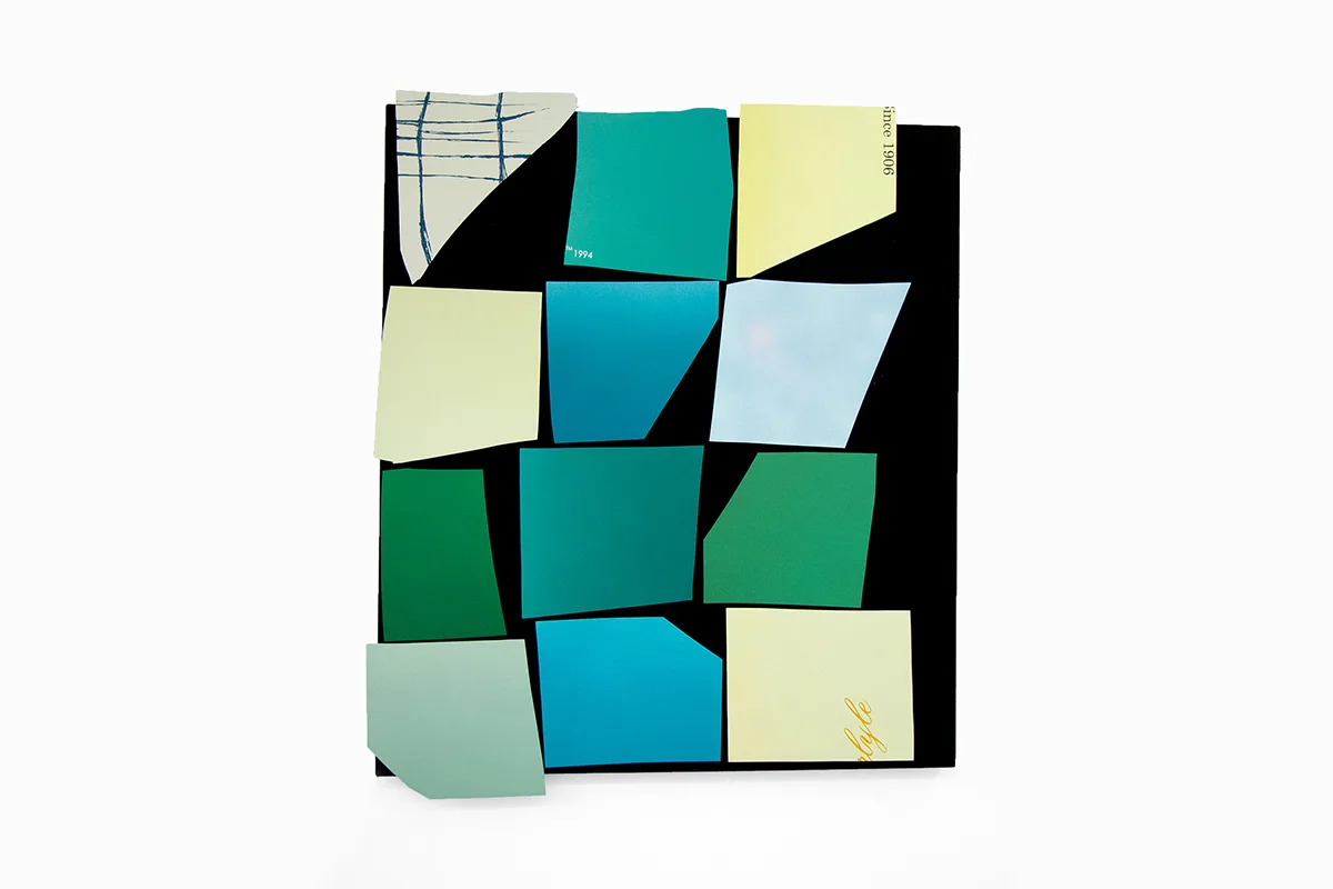 A work that features a black panel that has green papers collage on the surface