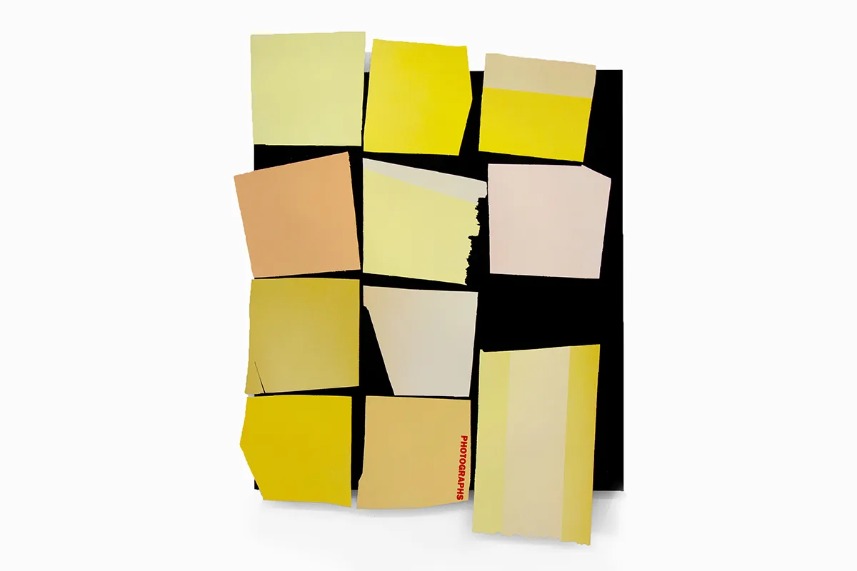 A work that features a black panel that has yellow papers collage on the surface