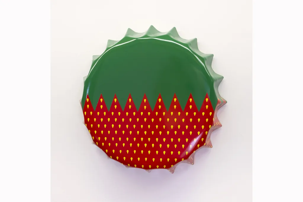 A metal cap-shaped painting features a strawberry