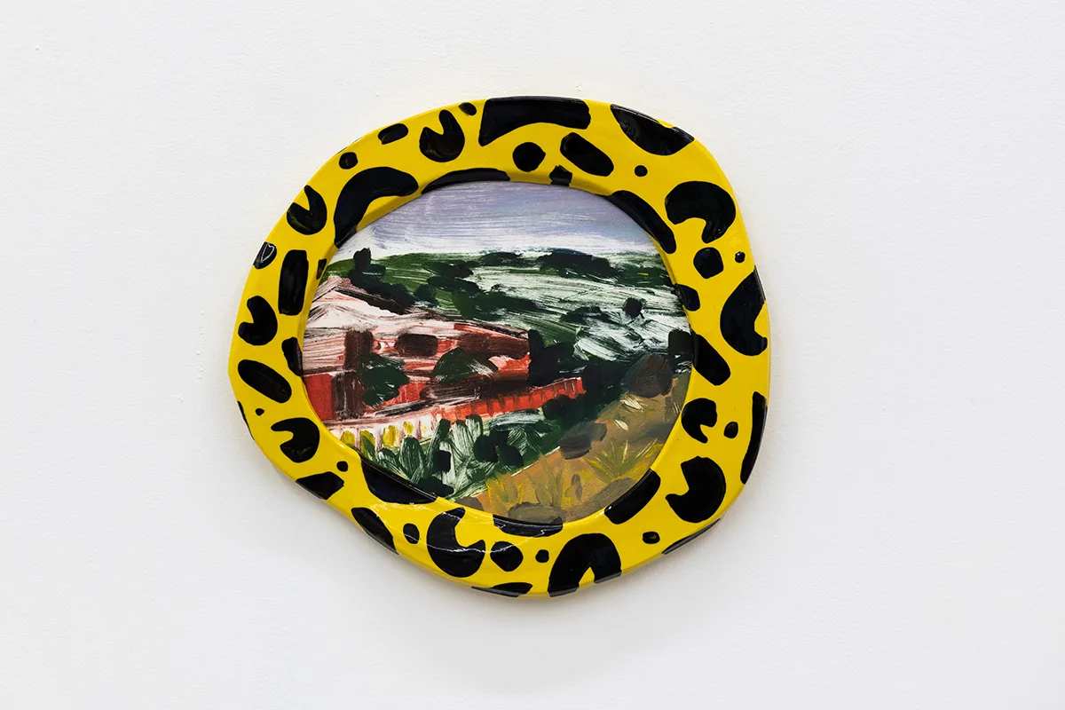 A painted frame with a painted landscape of a red barn and mountainside by artist Anna Valdez.