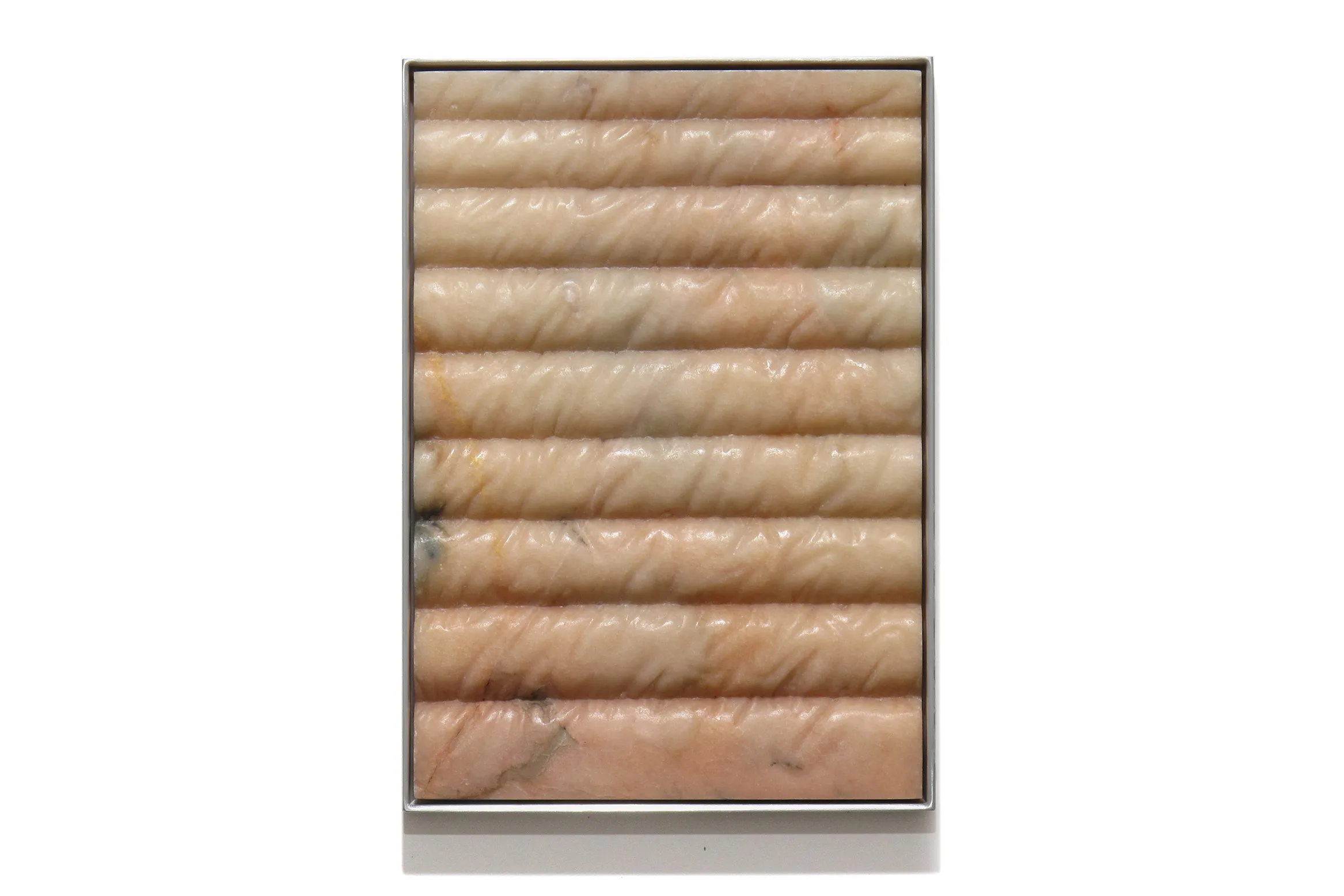 A carved marble sculpture by artist Devin Farrand depicting a puff jacket (pink marble).