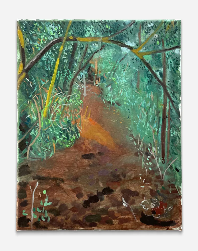 an image of a brown walk trail through green bushes and trees. A branch crosses from left to right in the foreground