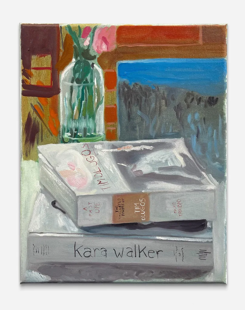 two books on a table next to a vase of flowers
