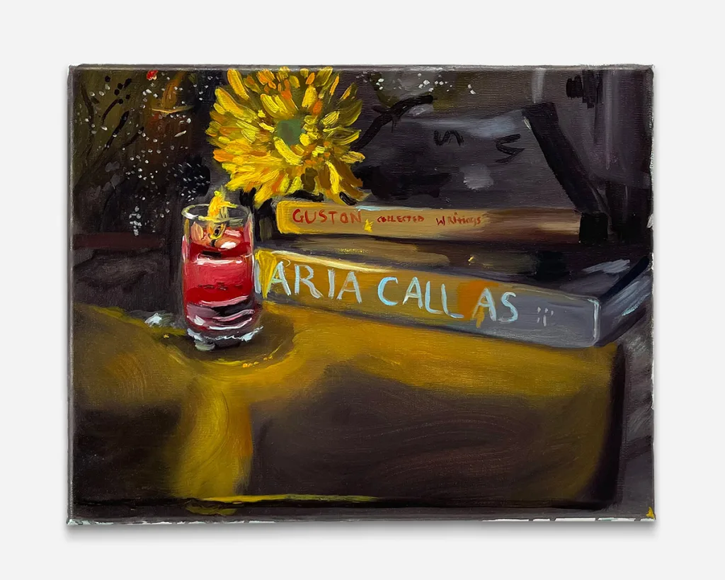 two books rest on a nightstand lit by a candle