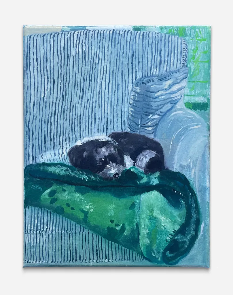 a puppy rests on top of a folded green blanket on a striped blue chair.