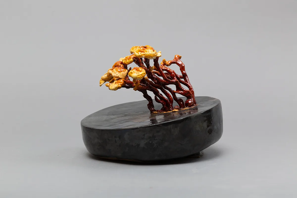 Image of a Sam Shoemaker piece featuring mushrooms sprouting out of a ceramic vessel
