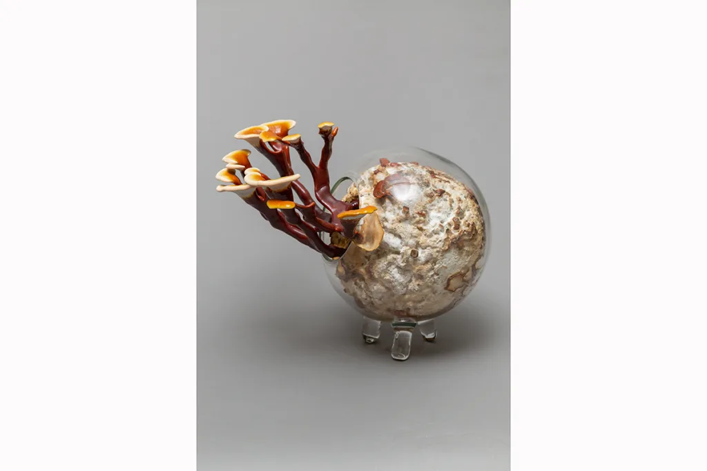 Image of a Sam Shoemaker piece featuring mushrooms sprouting out of a ceramic vessel