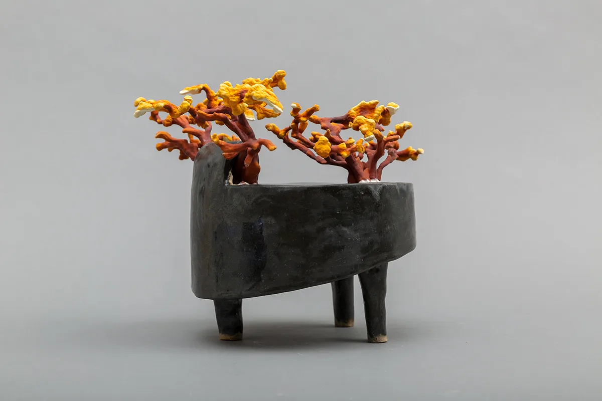 Image of a Sam Shoemaker piece featuring mushrooms sprouting out of a ceramic vessel