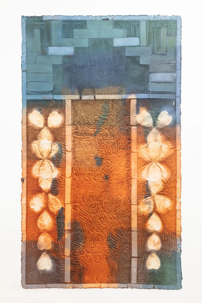 Multi colored handmade paper with brick and metal fencing patterns embossed on the surface.