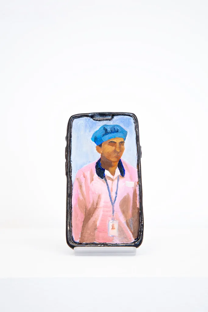 Image of Young Joo Lee’s Unknown Worker #2, a glazed ceramic iPhone with a portrait painted on its surface.