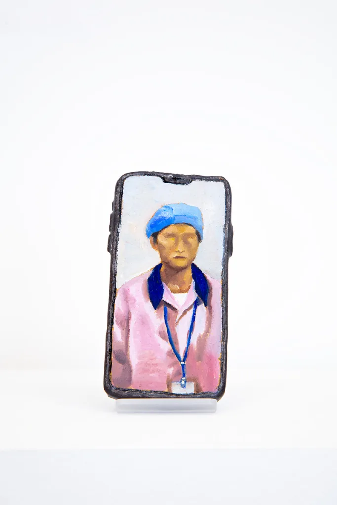 Image of Young Joo Lee’s Unknown Worker #4, a glazed ceramic iPhone with a portrait painted on its surface.