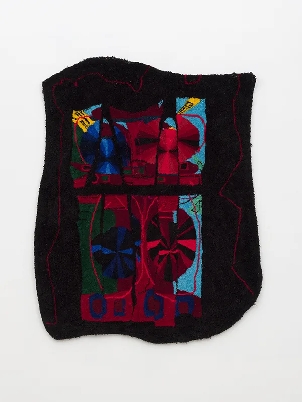 A black piece of art shows puzzle parts with the image of color wheels. There are red and blue mostly on the wheel.