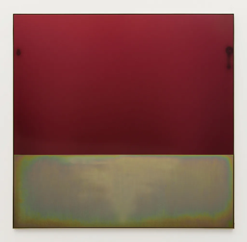 A flat, deep red plate of anodized aluminum sits above a sandblasted plate of yellow zinc plated steel, within a frame of the same steel. The works overall dimension is almost square and the top plate is about twice the height of the bottom one. The yellow zinc plated steel below has cloud like sandblasting marks in its center in a very light triangular shape and the whole piece reflects ambient light.