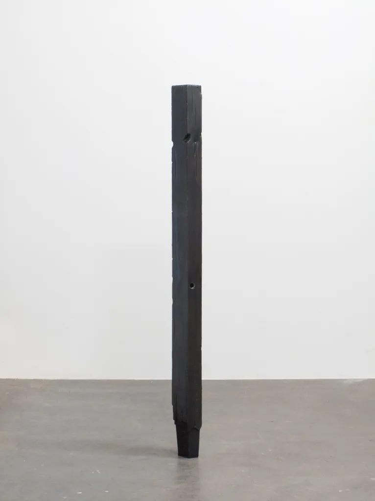 A to-scale steel sculpture that resembles a weathered fence post.