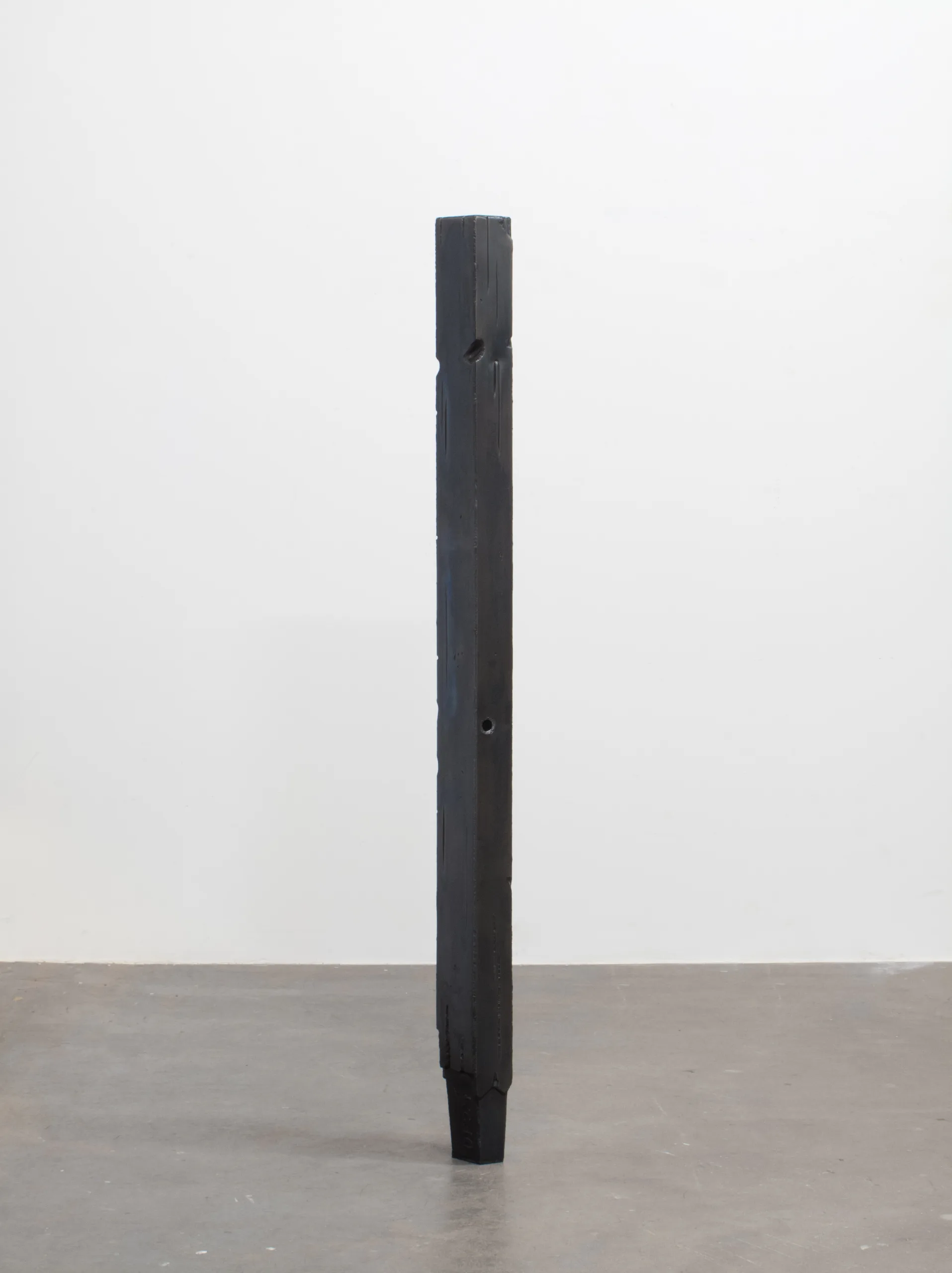A to-scale steel sculpture that resembles a weathered fence post.