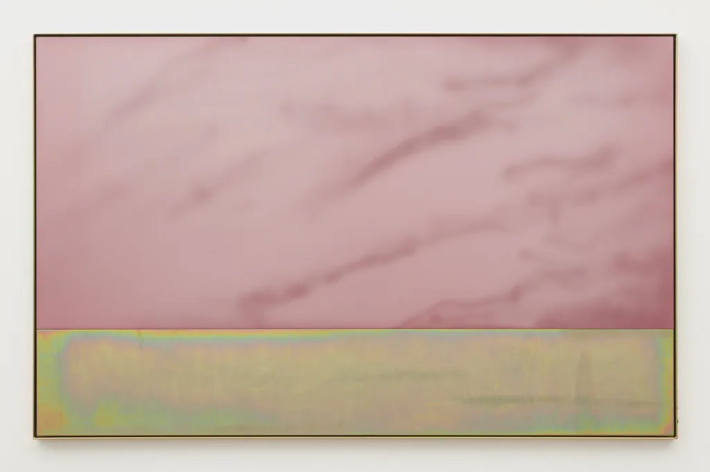 A light pink plate of anodized aluminum with cloud like sandblasted marks sits within a yellow zinc plated steel frame. Nestled within the same frame is a plate of yellow zinc plated steel with slight horizontal sandblasting.