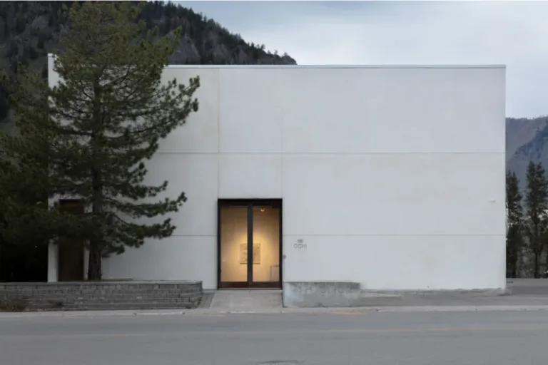 exterior image of ochi, idaho. a white building surrounded by trees and mountains